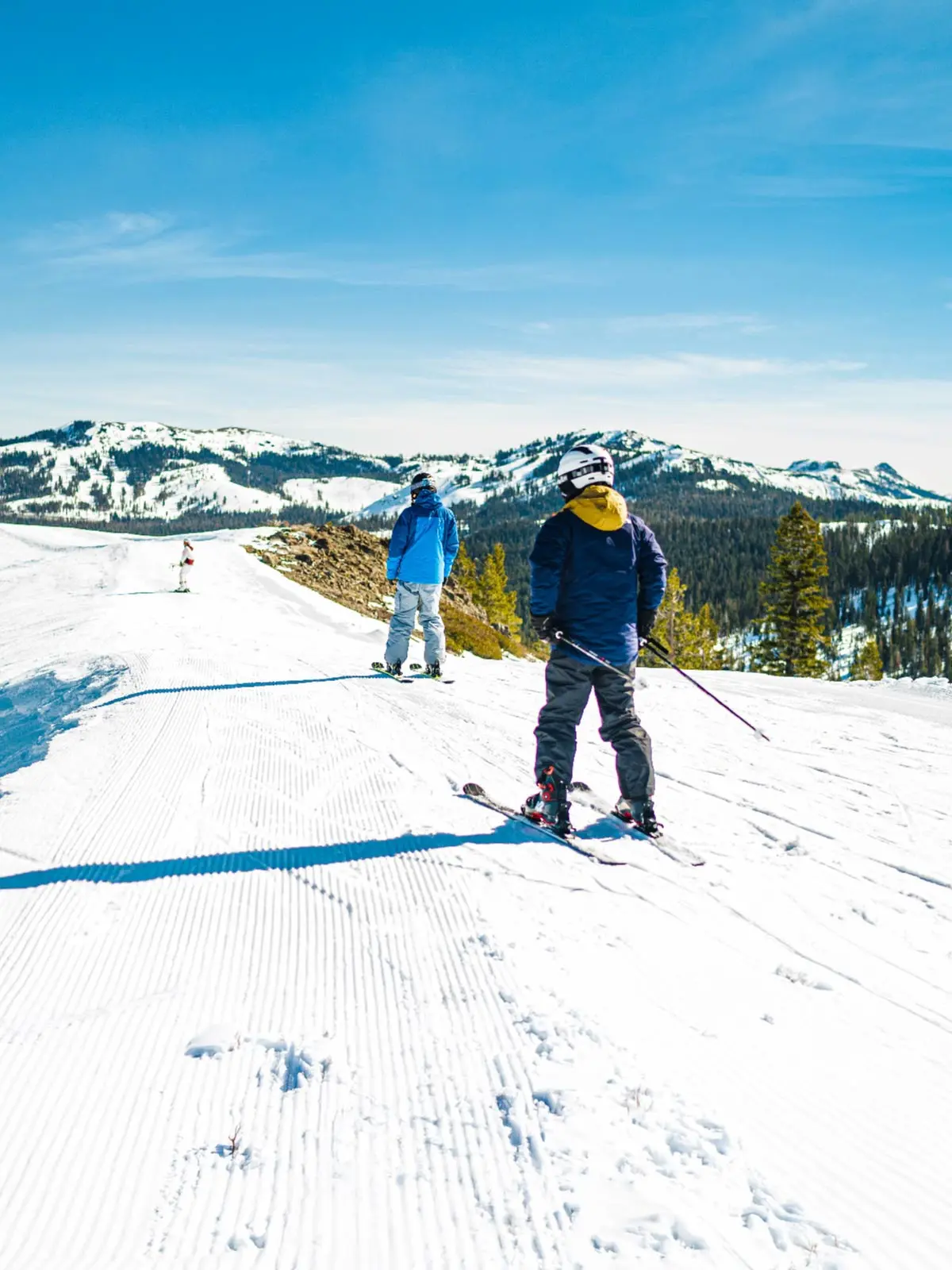 2 skiers at the top of Soda Springs on a sunny day